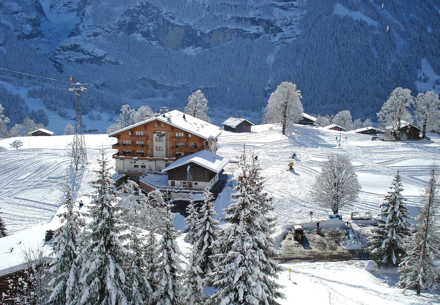 Das Bodmi Skihotel steht inmitten einer Skipiste, umgeben von schneebedeckten Bäumen und Bergen.