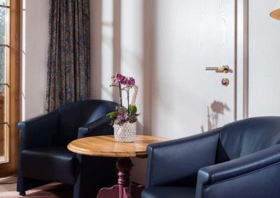 Gemütliche Zimmerausstattung mit schwarzen Ledersesseln im Bodmi Romantikhotel in Grindelwald